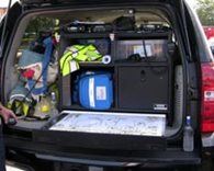 A black vehicle with the back end opened up.